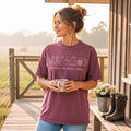 Purple unisex t-shirt with chicken, coffee, and flowers graphic in white ink