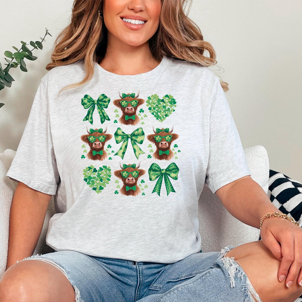 Heather gray unisex shirt with green shamrocks, bows, and cartoon highland cow heads