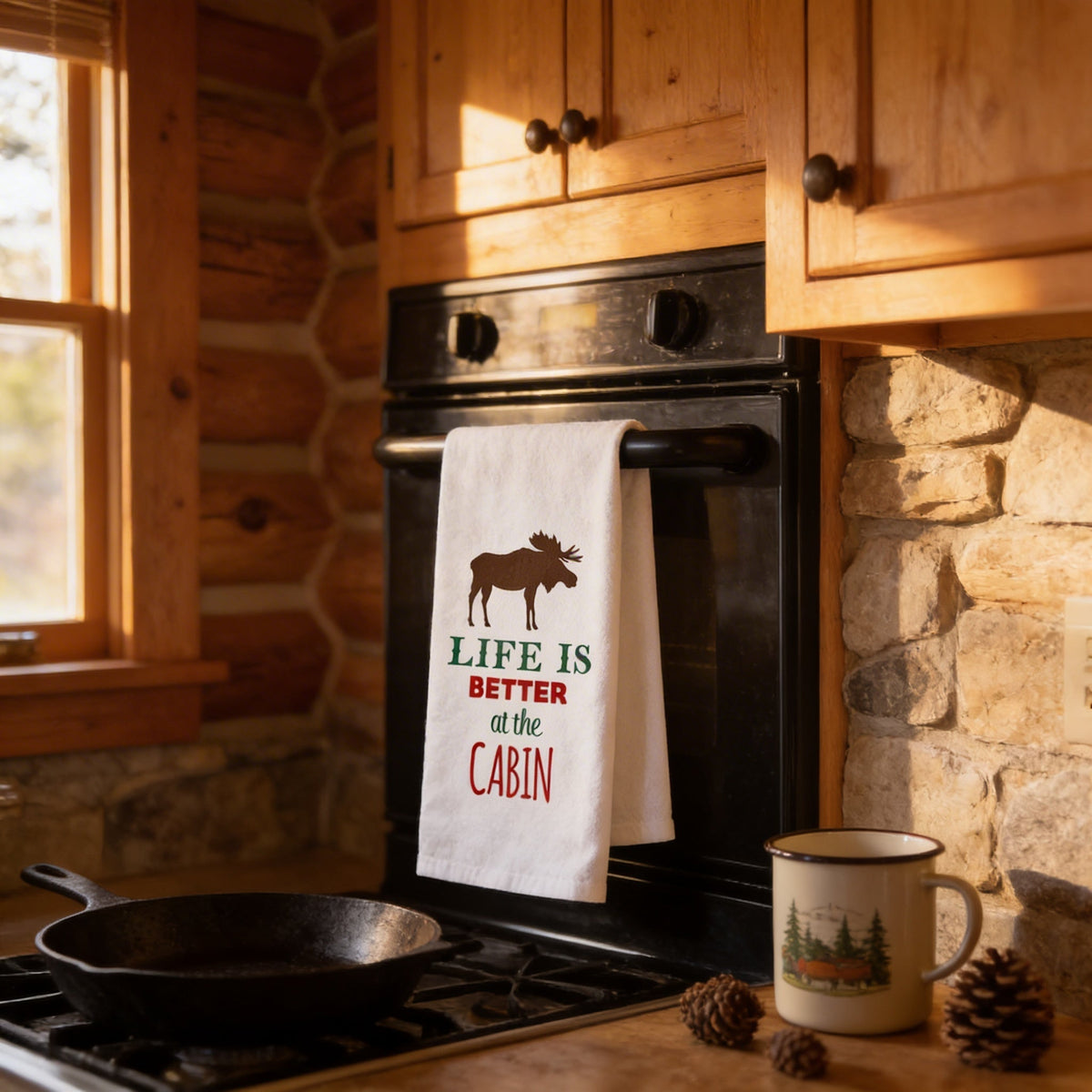 White flour sack towel hanging on oven with moose graphic and 'Life is Better at the Cabin' text