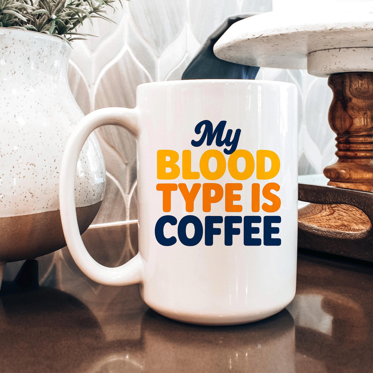 White ceramic coffee mug with handle, “My BLOOD TYPE IS COFFEE” graphic design.