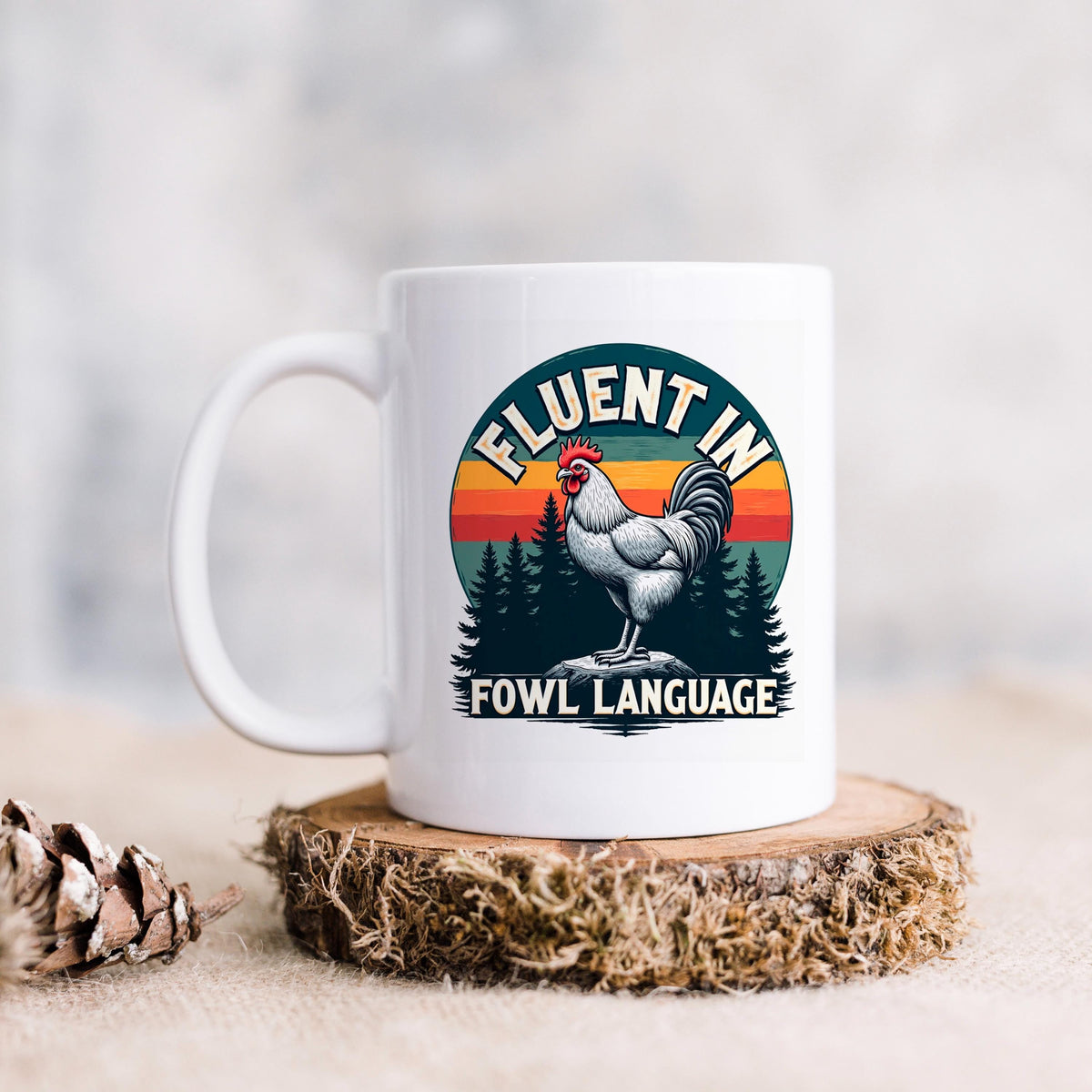 White ceramic mug with rooster graphic and “FLUENT IN FOWL LANGUAGE” text