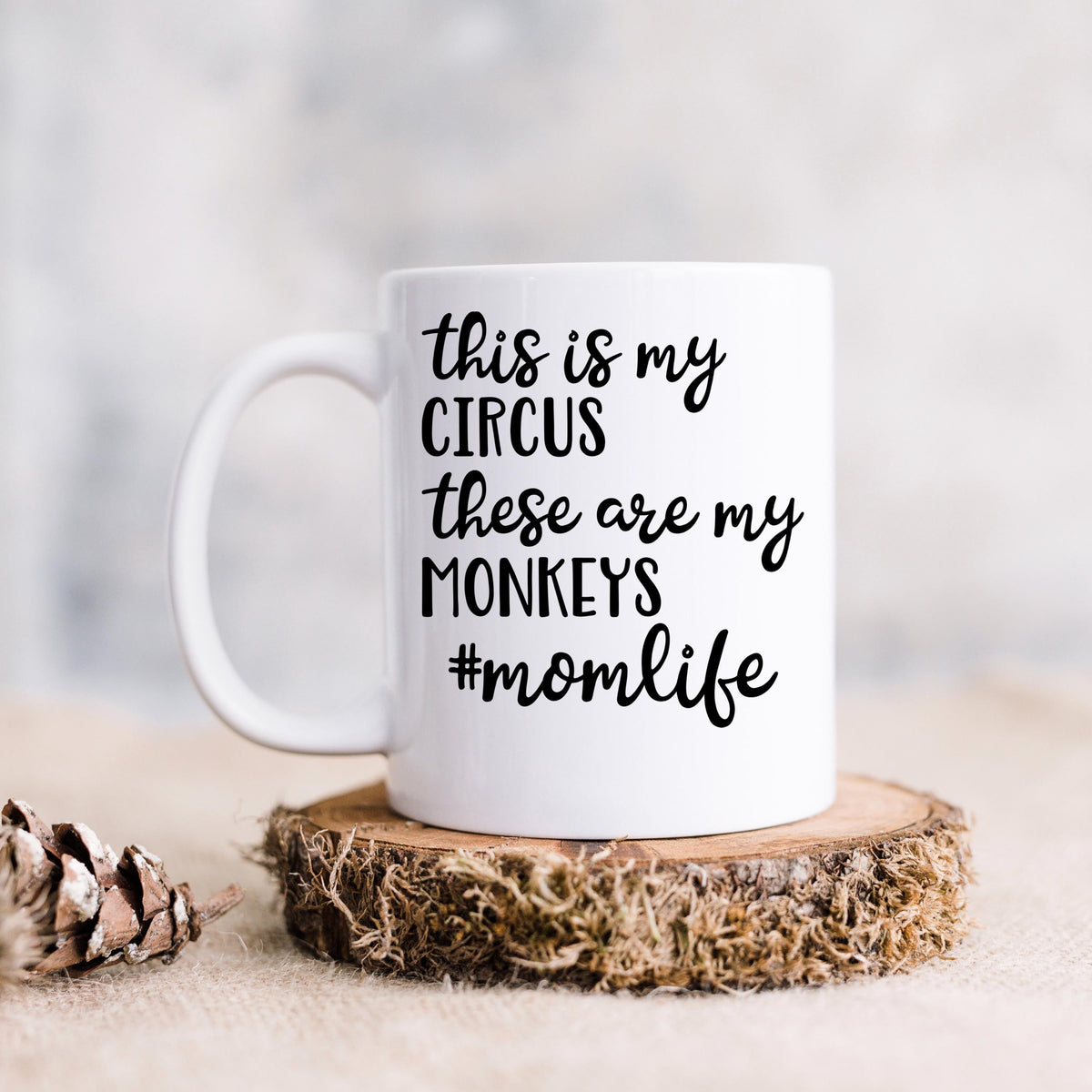 White ceramic coffee mug with "Circus" momlife message on a wooden coaster