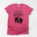 Pink unisex dog mom T-shirt with “Life is better” text and black dog graphic
