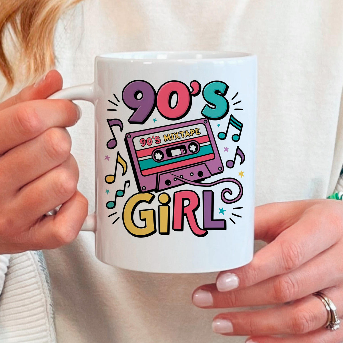 White ceramic mug held by hands, with 90's Girl cassette tape graphic