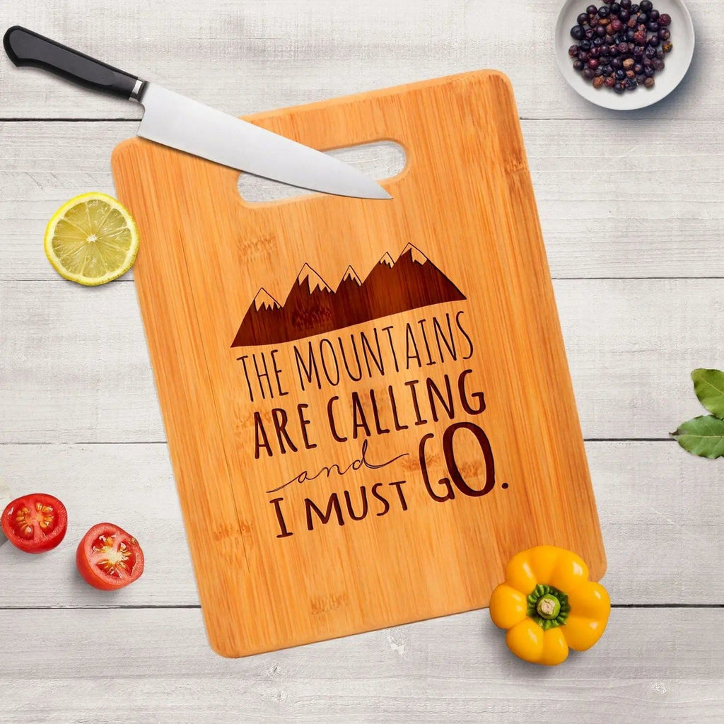 Bamboo cutting board with handle cutout and mountain quote "The mountains are calling and I must go"