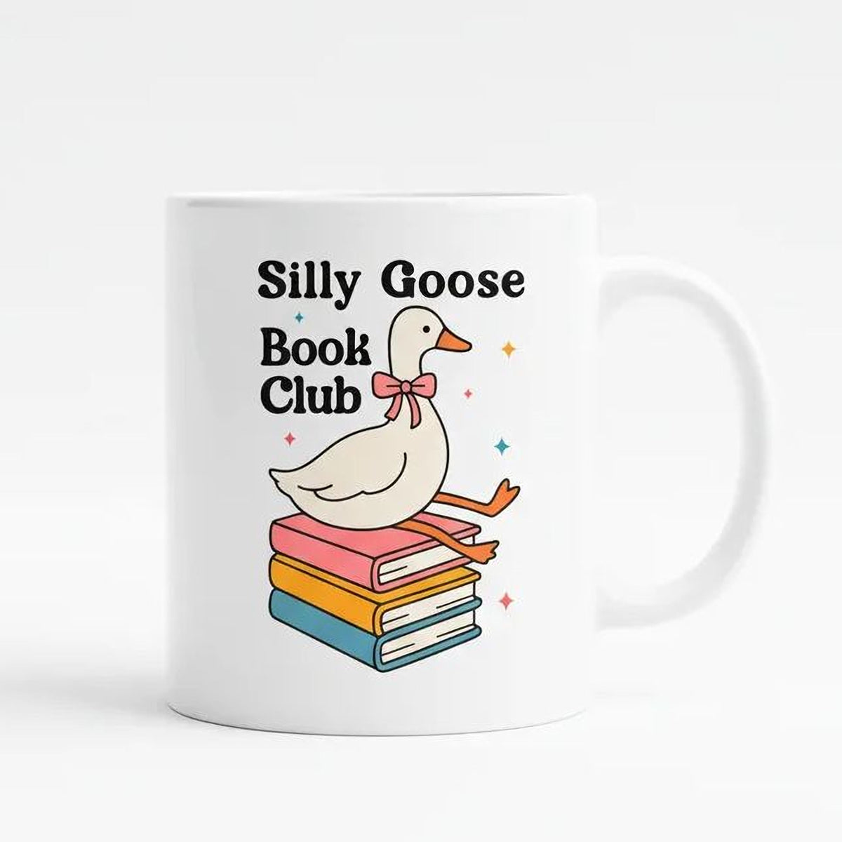 White ceramic mug with cartoon goose and stacked books, text 'Silly Goose Book Club'.