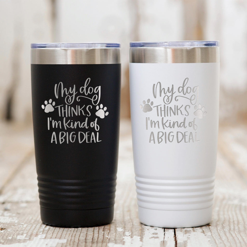 Black and white stainless steel travel tumblers with dog paw quote: “My dog thinks I’m kind of a big deal”.