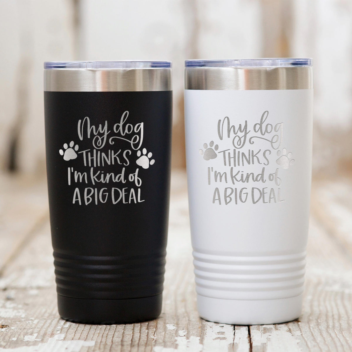 Black and white stainless steel travel tumblers with dog paw quote: “My dog thinks I’m kind of a big deal”.