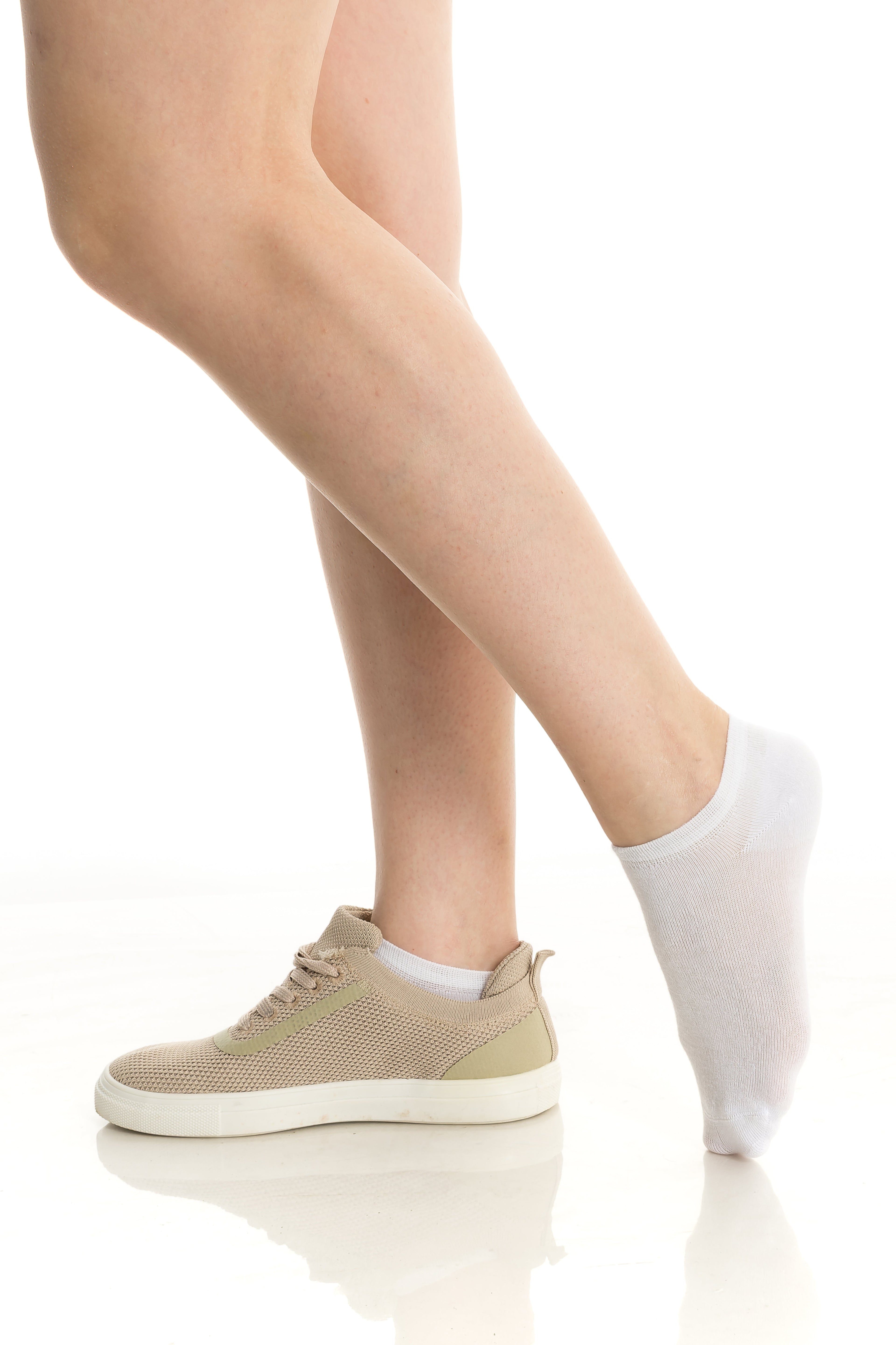 Beige ankle socks on bare legs with casual sneakers