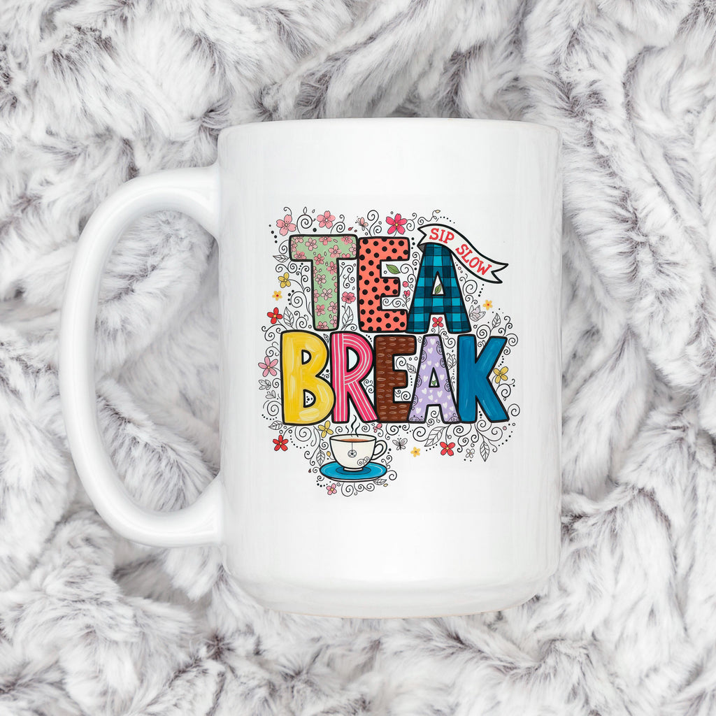 White ceramic tea mug with 'TEA BREAK' floral graphic, teacup icon and handle visible