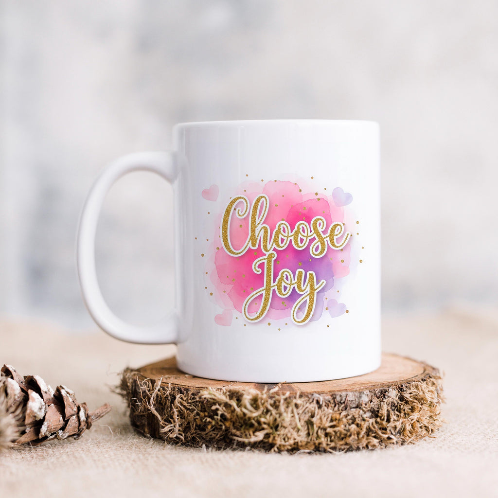 White ceramic coffee mug with pink watercolor "Choose Joy" text on center front