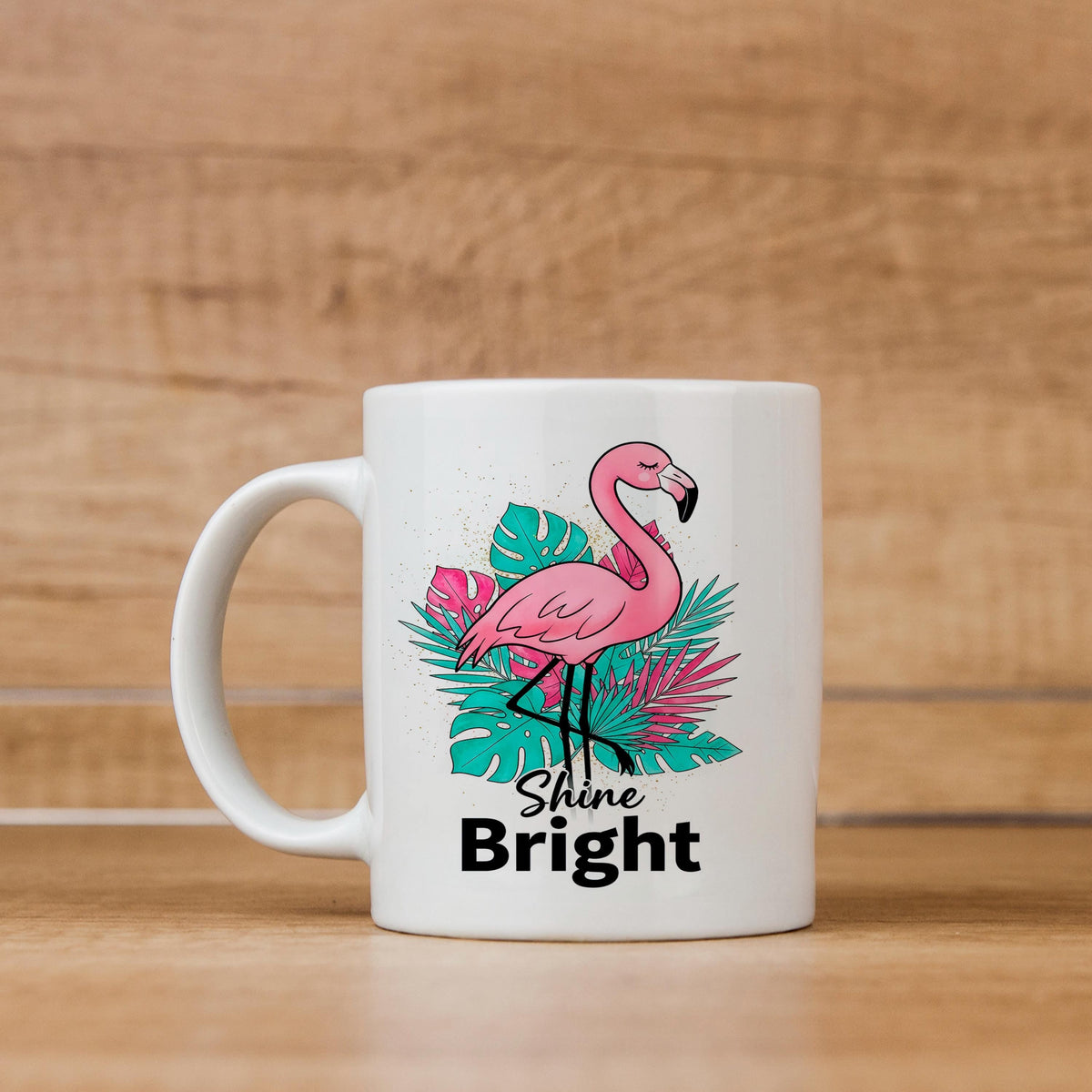 White ceramic mug with pink flamingo on tropical leaves and “Shine Bright” text