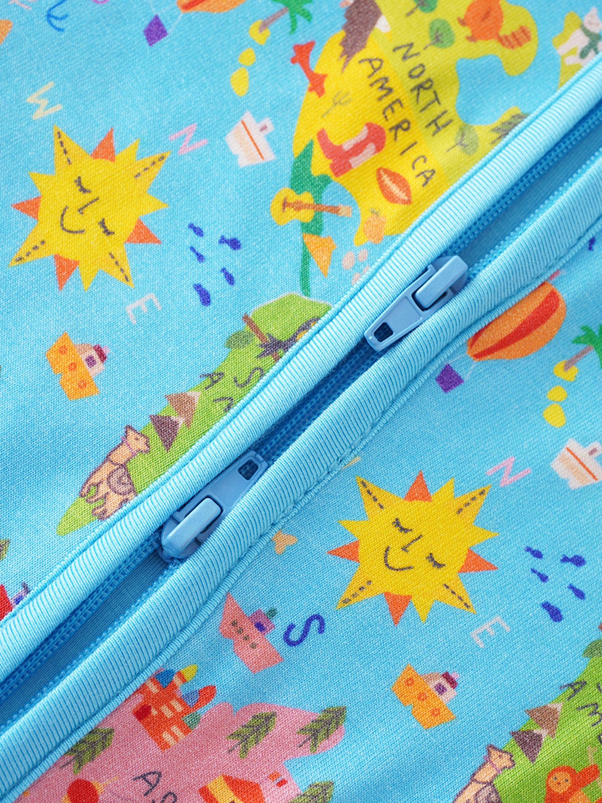 Baby bamboo romper close-up of front zipper with bright world map animal graphics