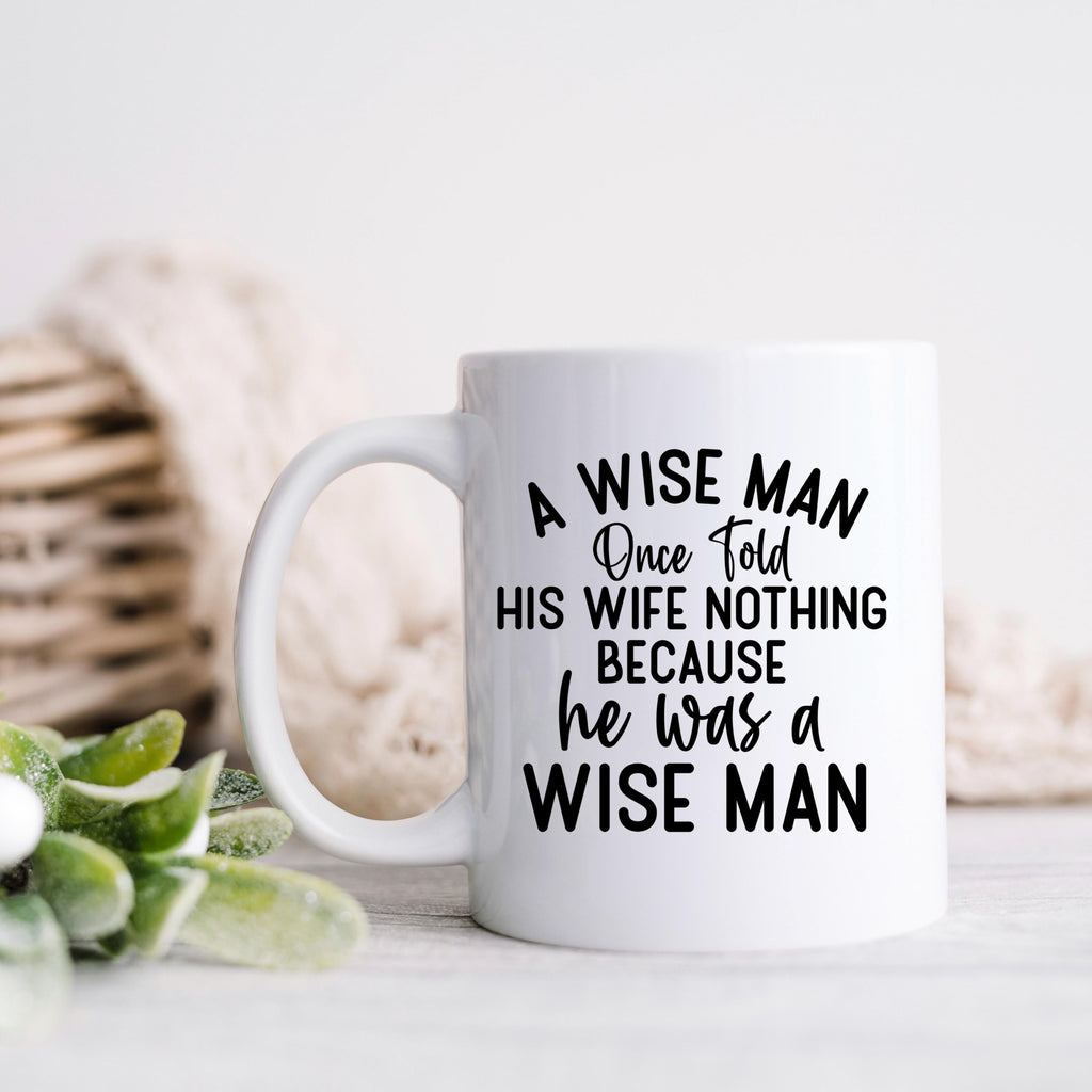 White ceramic coffee mug with "A WISE MAN" quote and decorative script lines
