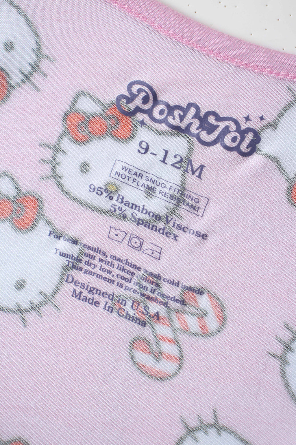 Inside label on pink Hello Kitty baby romper showing size and bamboo viscose details