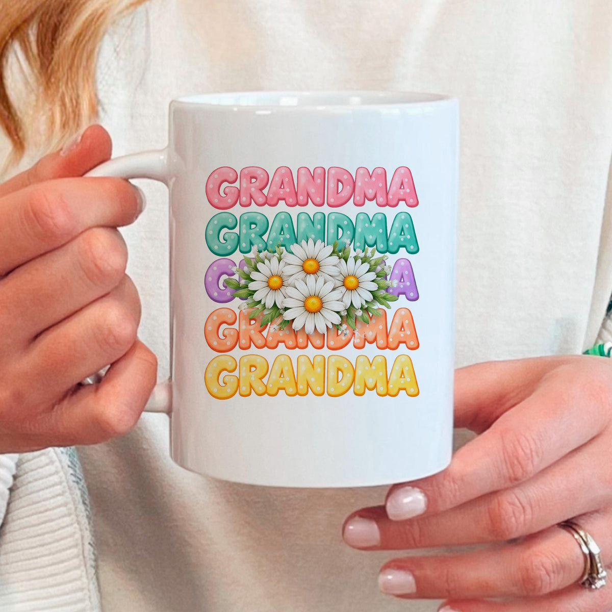 White ceramic coffee mug held in hands, Grandma text with daisy floral design