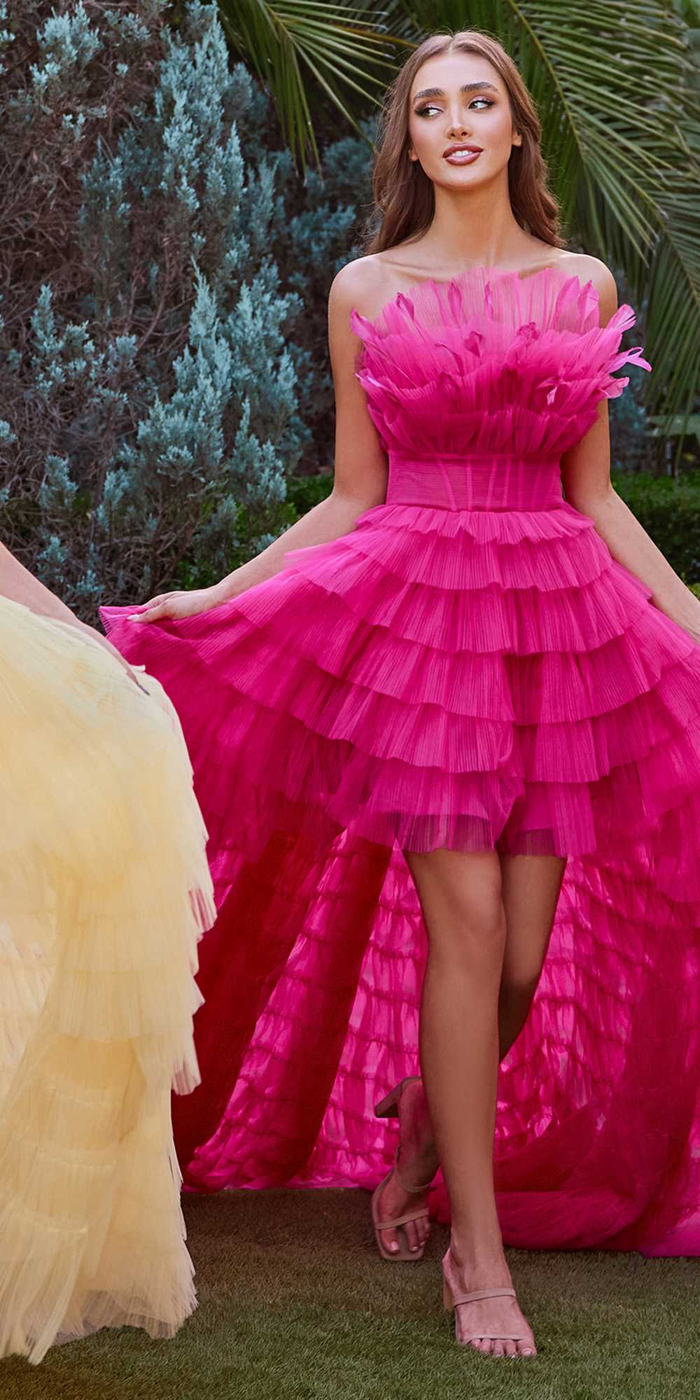 Fuchsia tiered tulle high-low gown with ruffled bodice and feather trim