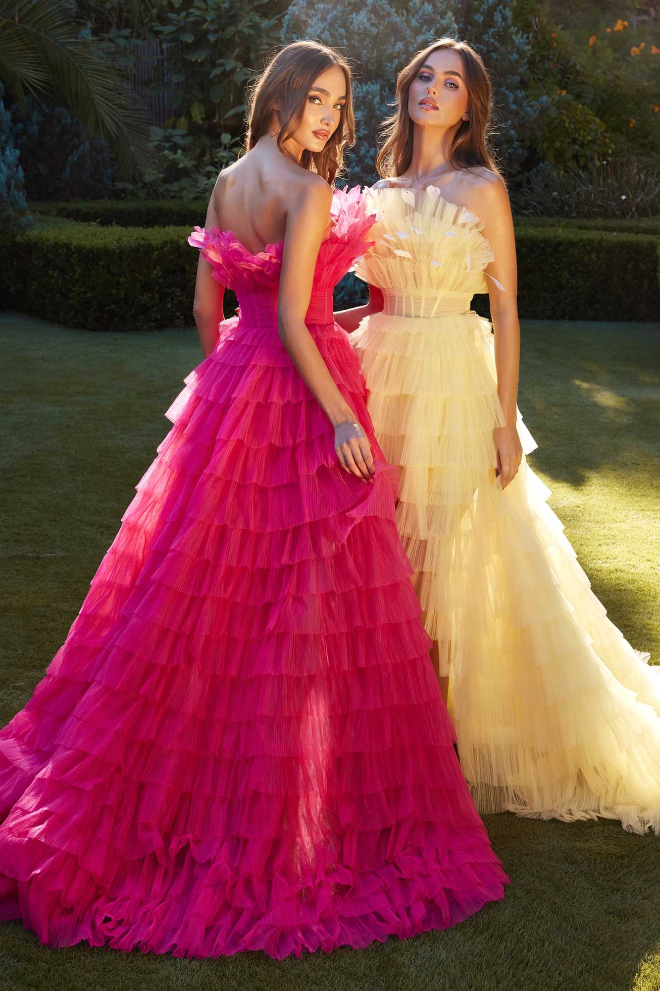 Two tiered tulle high-low gowns: fuchsia on left, pale yellow on right
