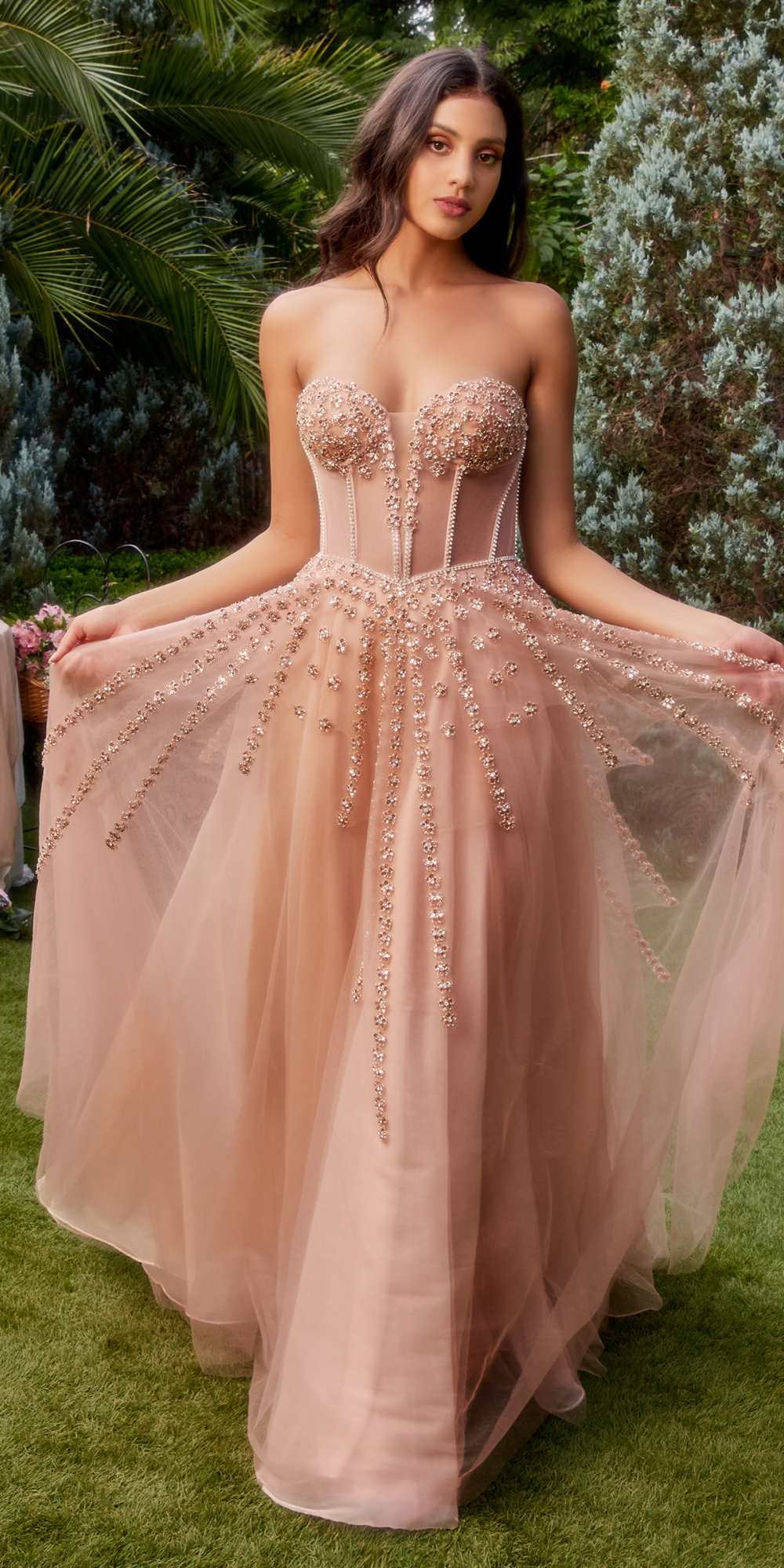 Rose gold strapless beaded gown with boned bodice, decorative sequins, and bow arm bands.