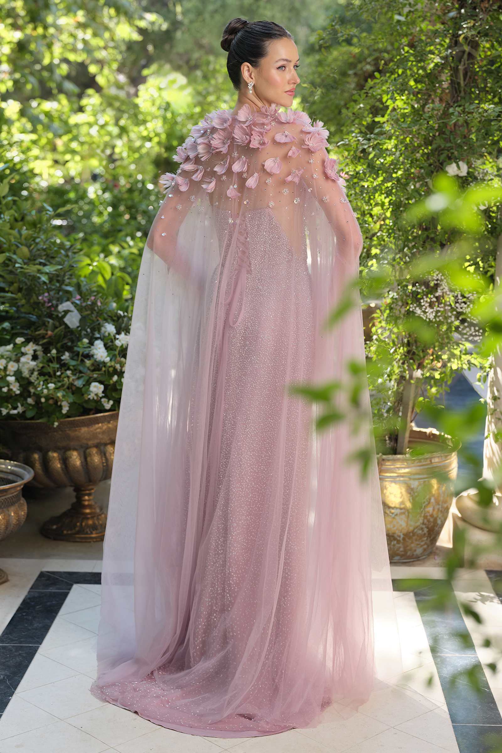 Dusty rose strapless gown with sparkling bodice, floral shoulder detail, flowing tulle cape