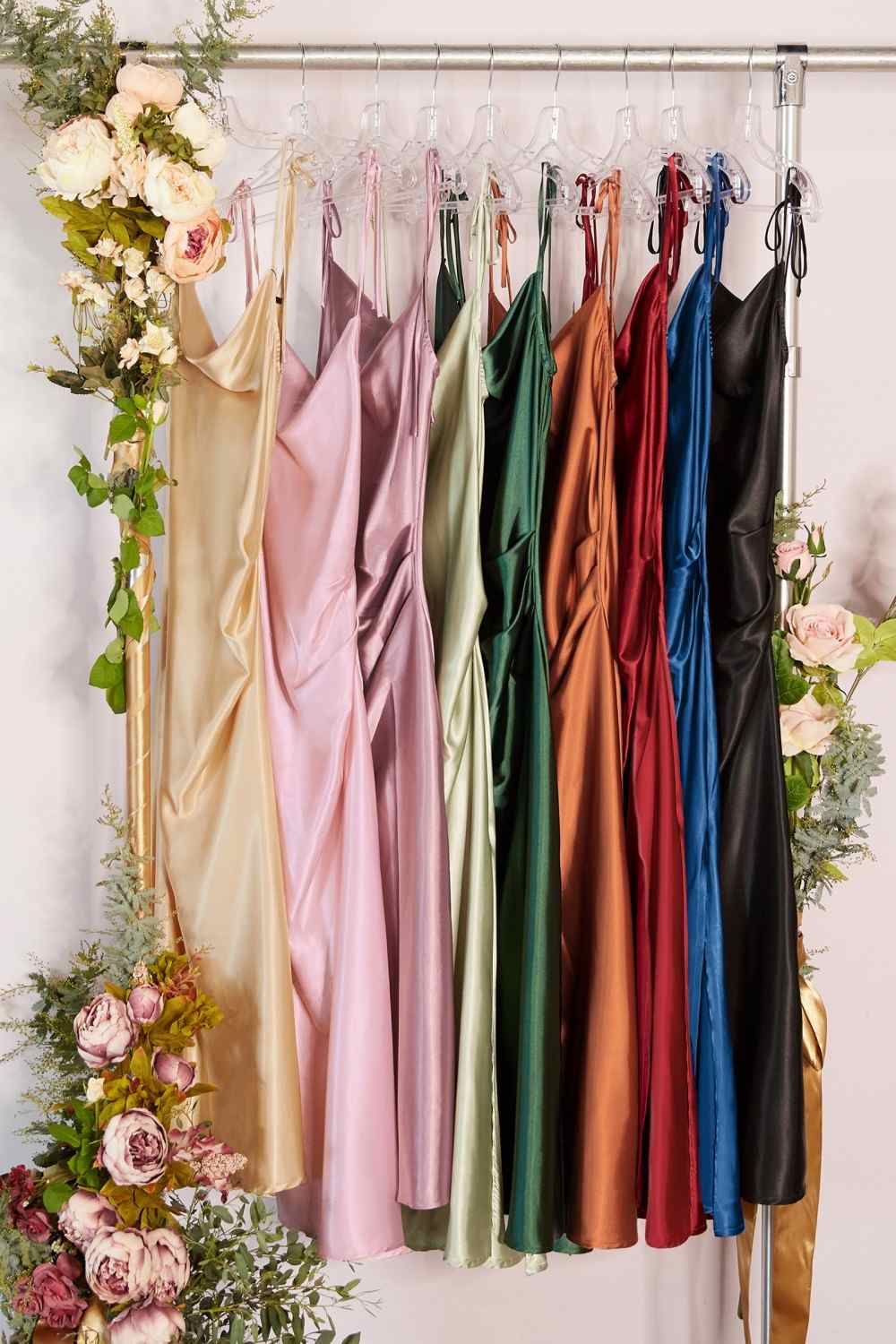 Assorted satin midi dresses on a hanging rack in multiple colors