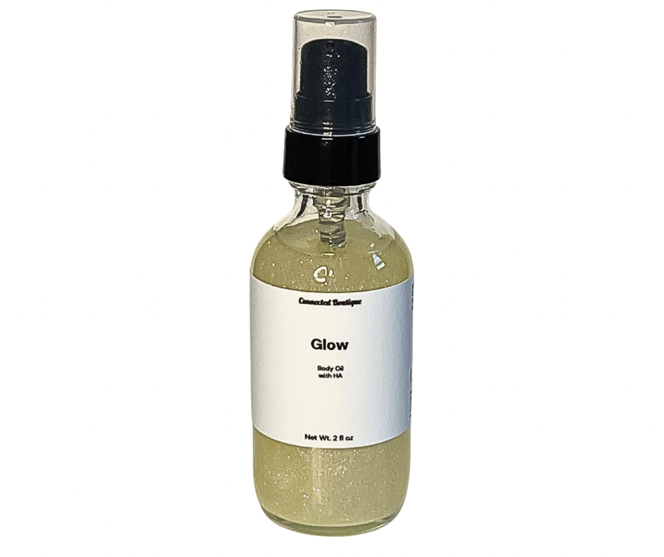Glow body oil spray bottle, clear glass with black pump, olive-gold liquid inside