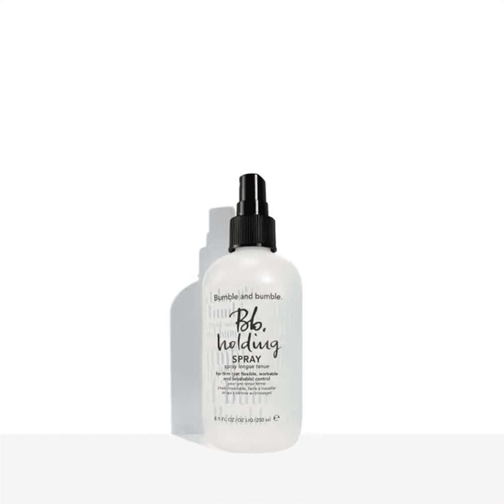 Bumble and bumble holding spray bottle with black pump, clear liquid
