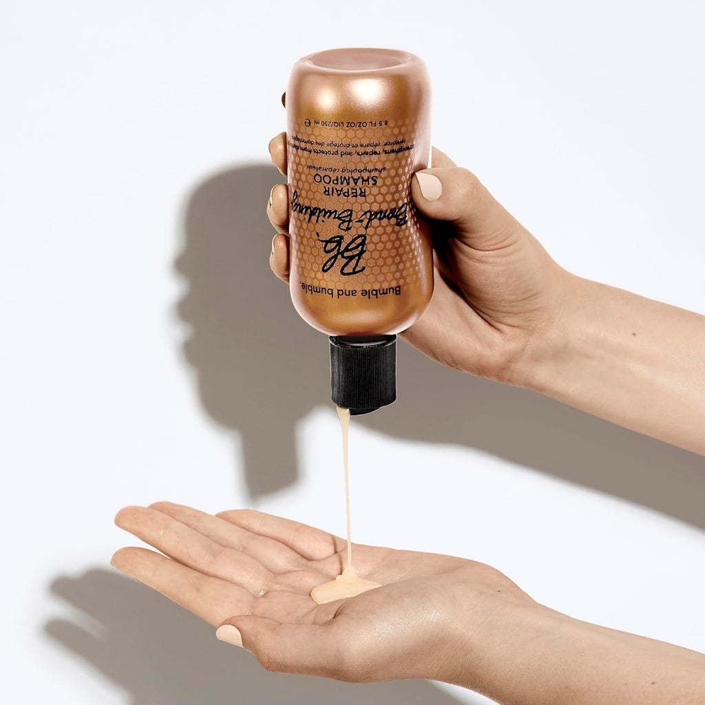 Bond-Building Repair Shampoo bottle held above palm as clear liquid pours