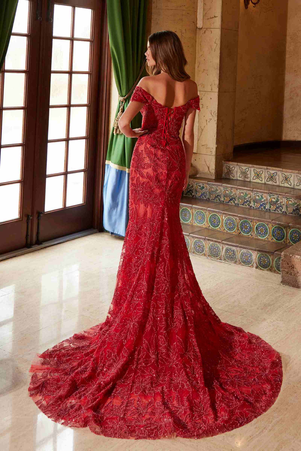 Red off-shoulder fully beaded long gown with flowing train and back view angle