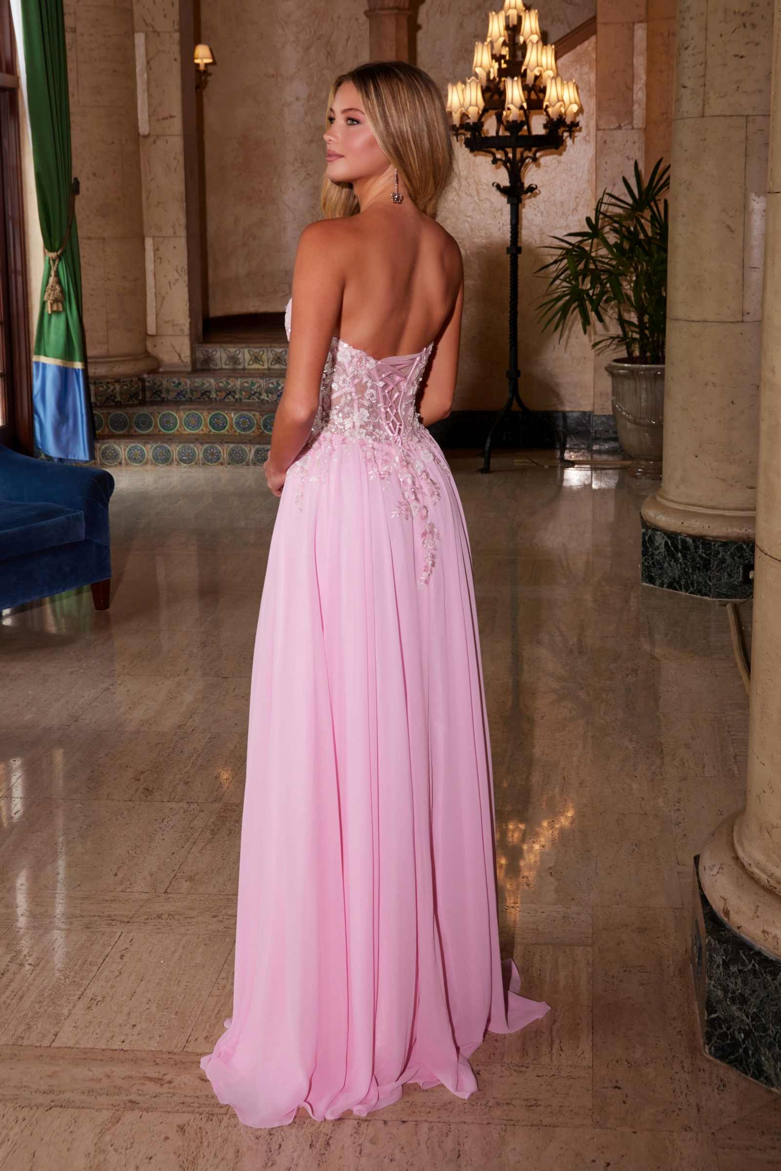 Pink strapless corset dress shown from back with chiffon skirt and applique detailing