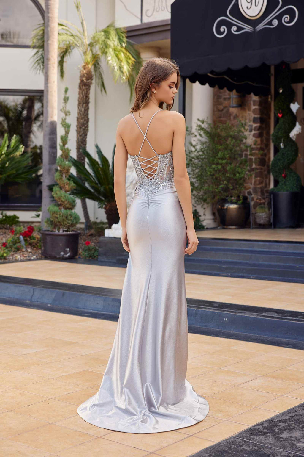 Silver satin prom gown from back view, open lace crisscross straps, long train