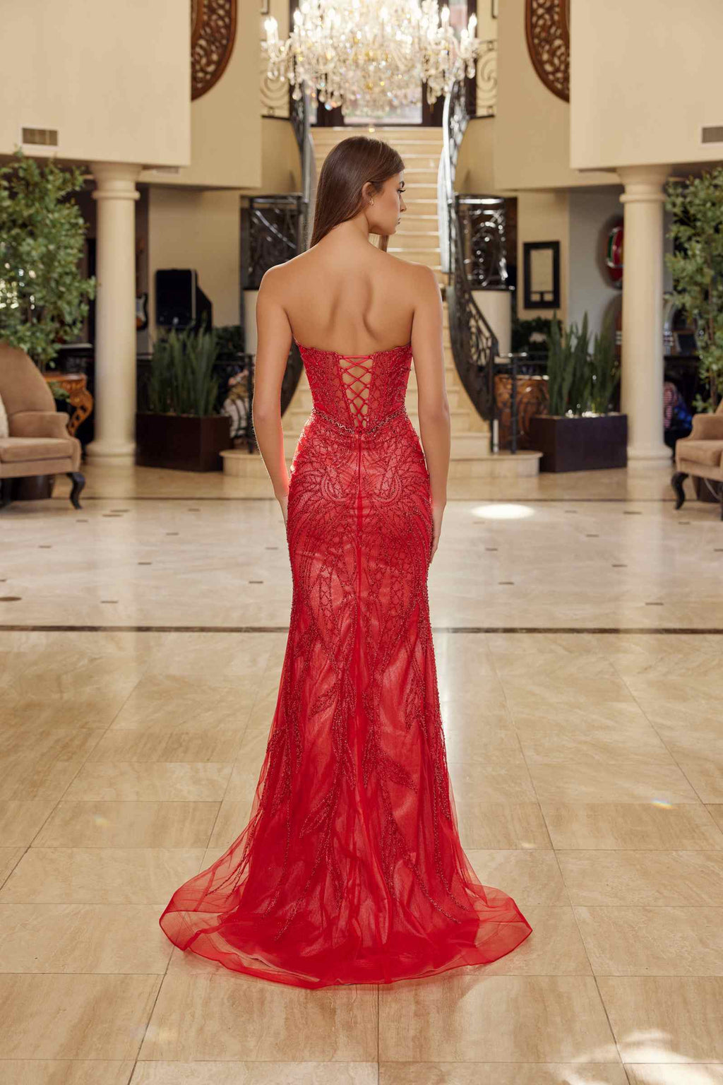Back view red strapless keyhole gown with beaded tulle bodice and flowing mermaid skirt