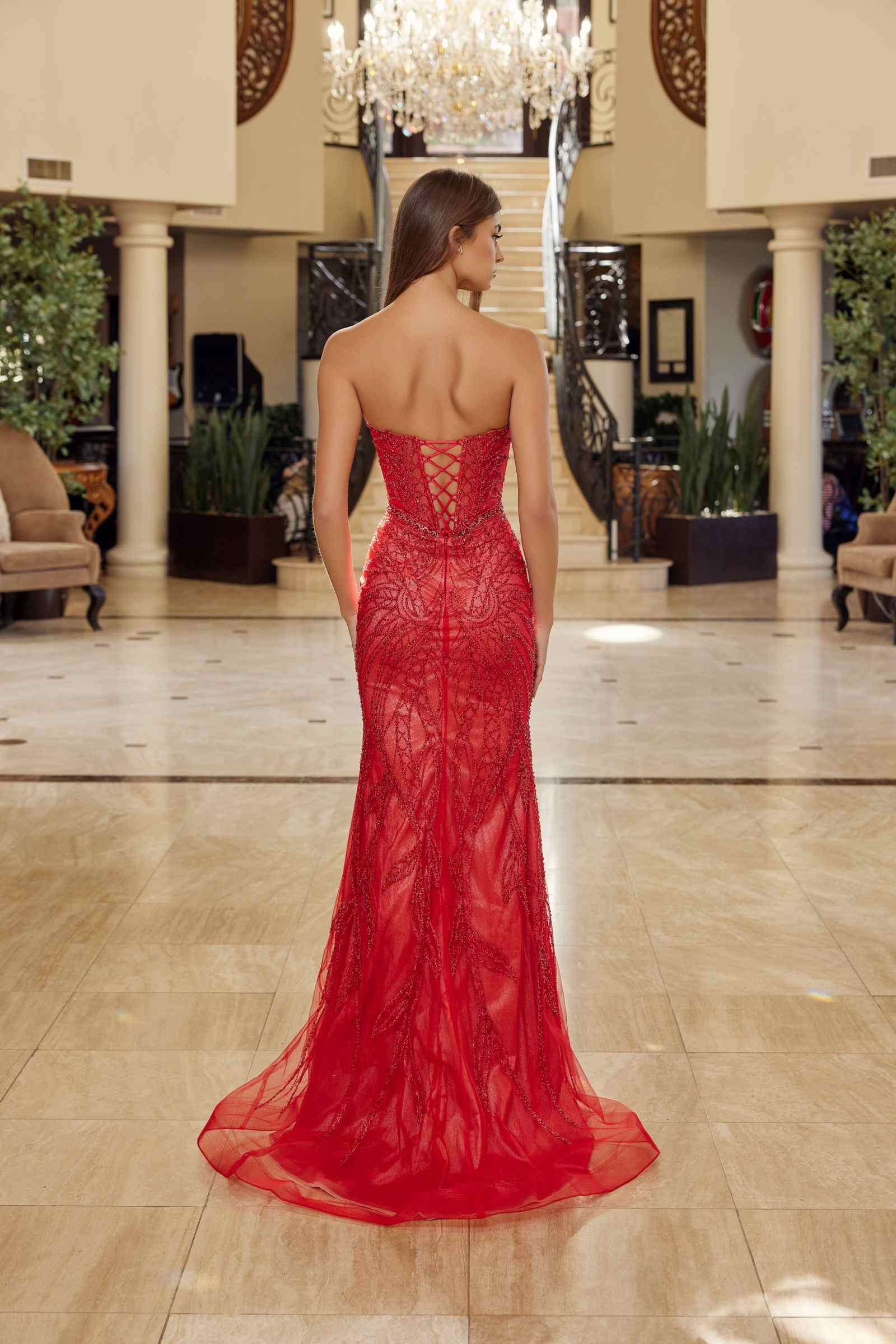 Back view red strapless keyhole gown with beaded tulle bodice and flowing mermaid skirt