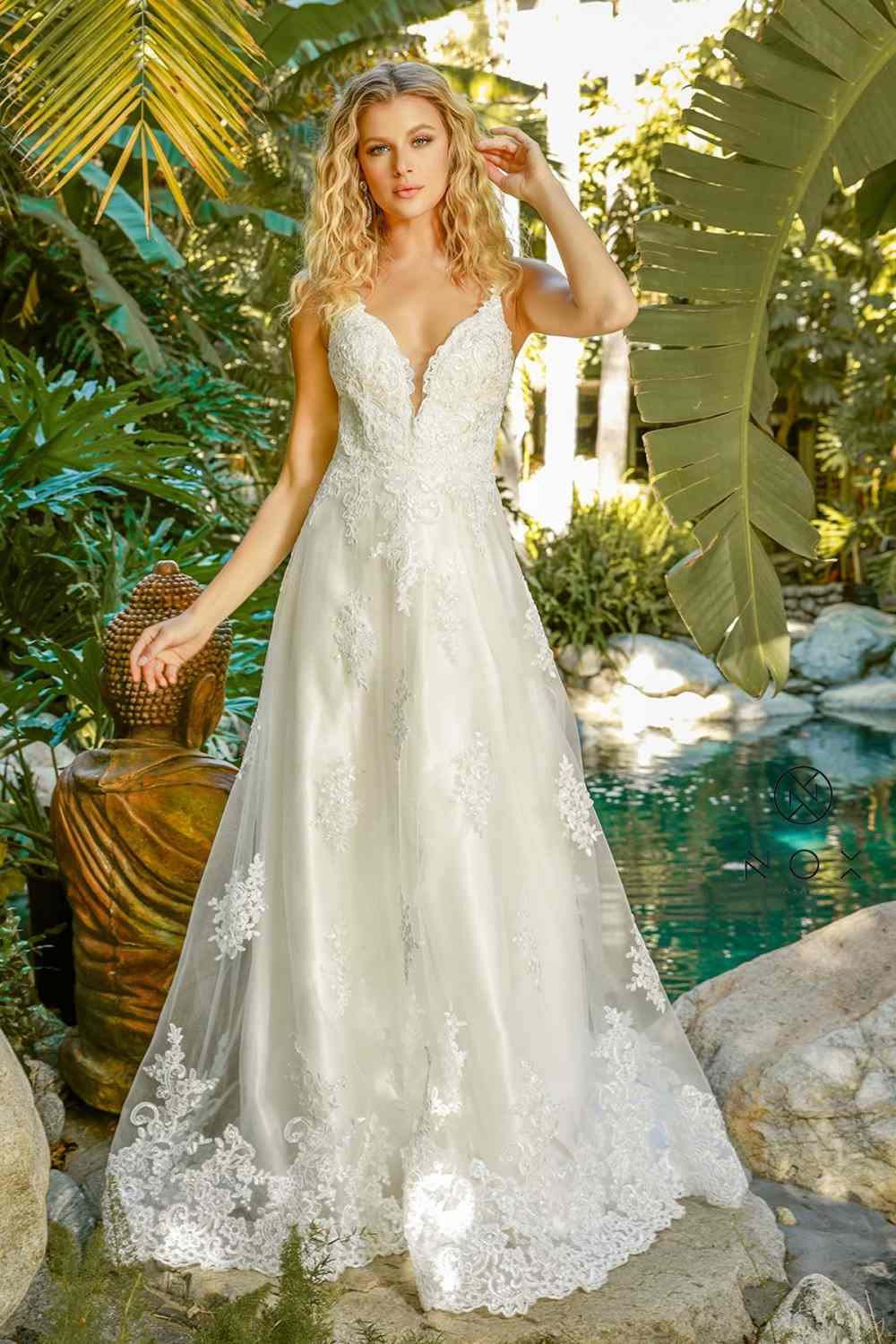 White lace A-line ball gown with V-neck, lace straps, and embellished skirt hem.