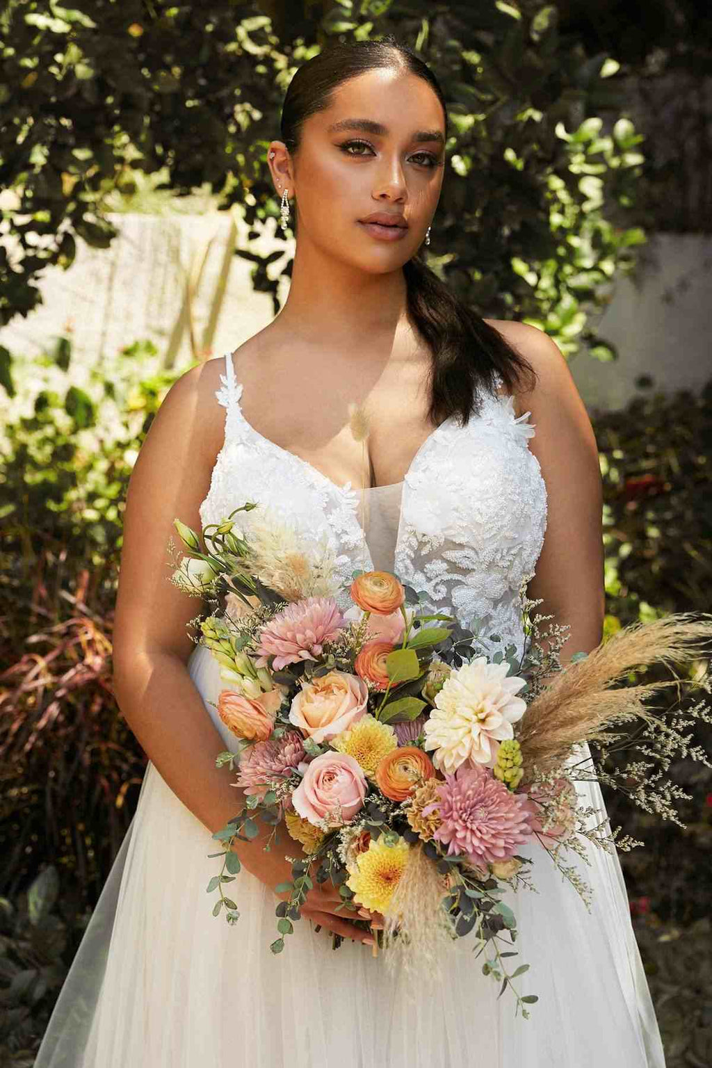Off-white layered tulle bridal gown with lace-embroidered bodice and thin spaghetti straps