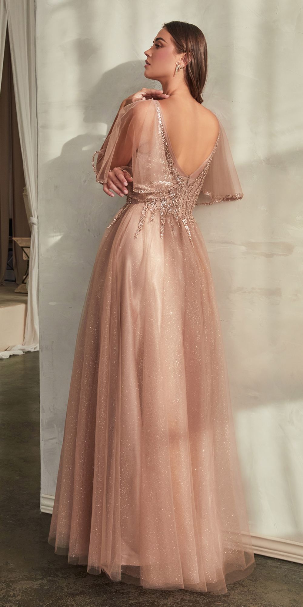 Rose gold tulle A-line gown with open-back V and sheer butterfly sleeves.