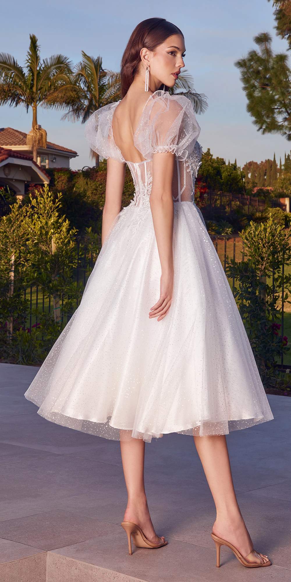 White tea-length layered tulle dress with lace bodice and short puff sleeves, side view