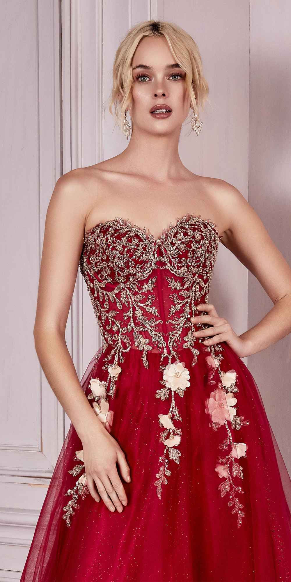 Red strapless corset gown with ornate floral embroidery and layered tulle skirt