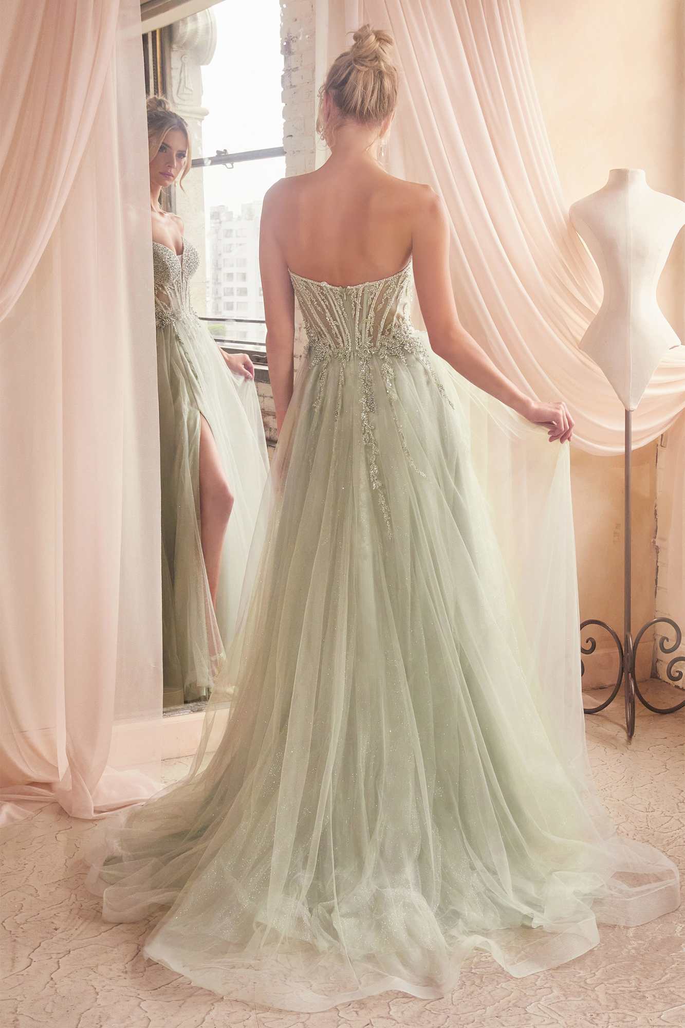 Sage green strapless ballgown from back view with beaded corset and layered tulle