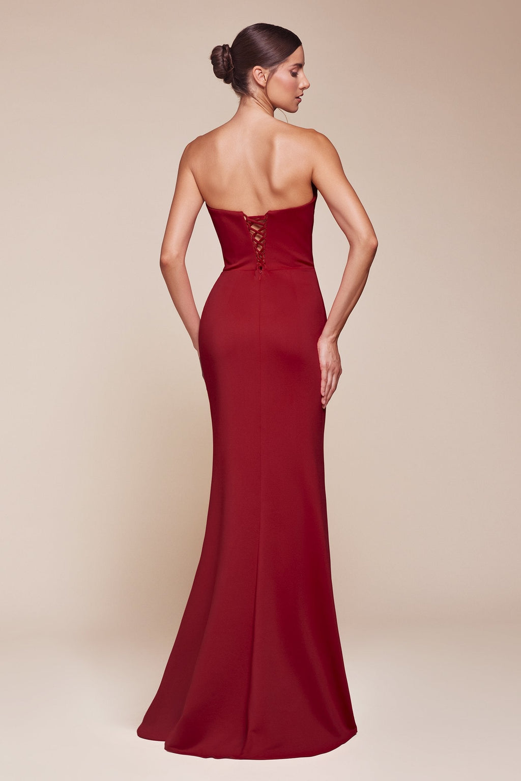 Burgundy strapless long gown seen from back, ruched bodice and draped skirt