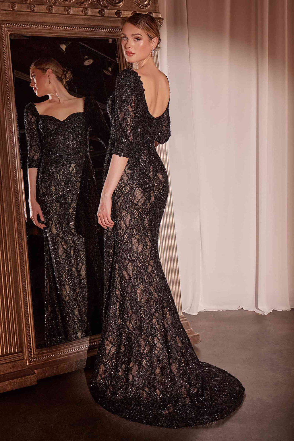 Black lace mermaid gown with one long sleeve, fitted waist, and full-length train