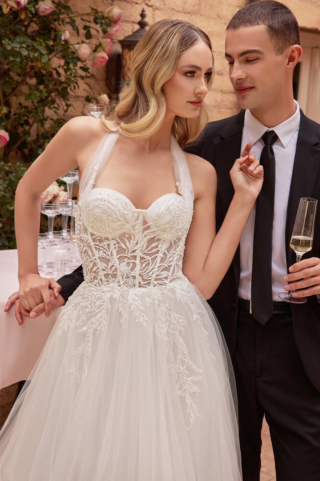 Off-white tulle wedding gown with lace corset bodice and textured floral appliqué skirt