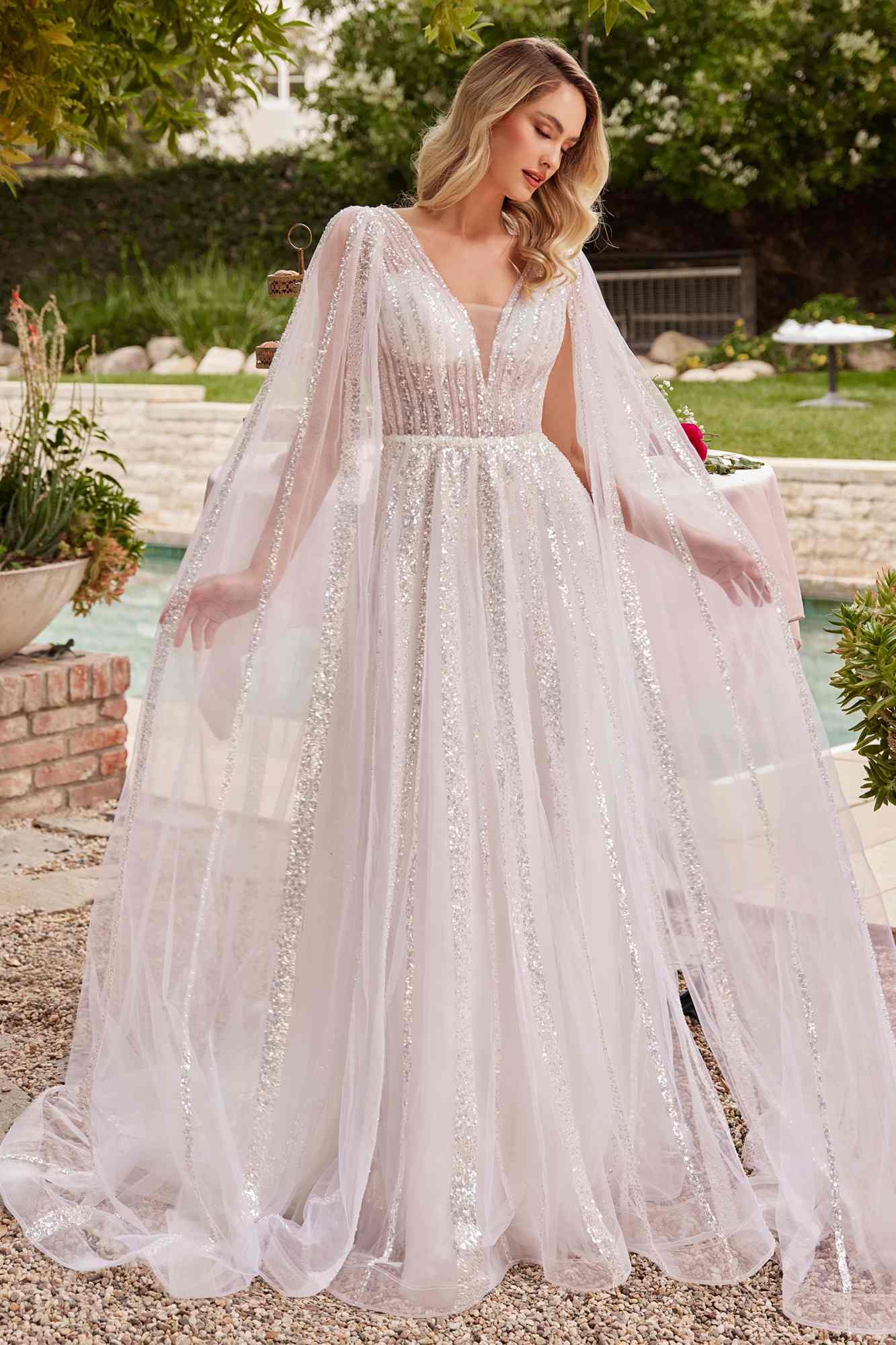 Off-white A-line wedding gown with flowing layered tulle skirt and long sheer sleeves