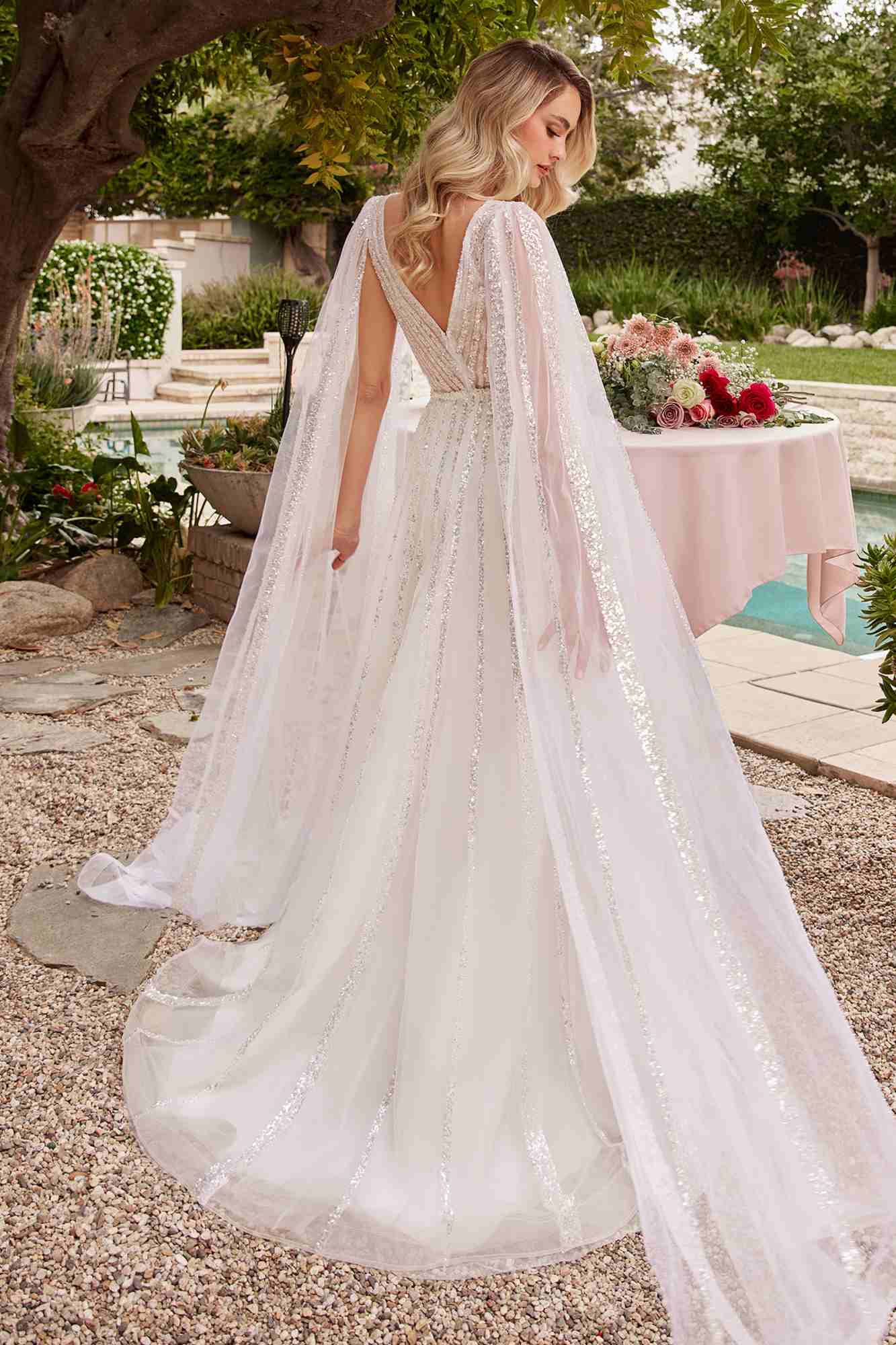 Off-white A-line wedding gown with layered tulle skirt and open-back V-shaped detail
