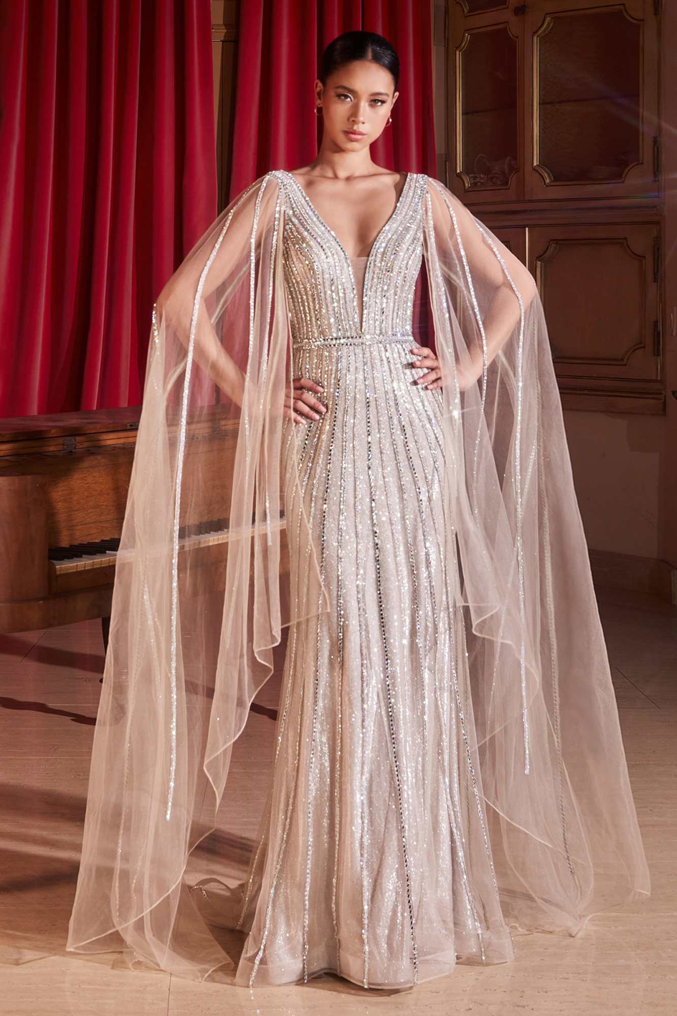 Platinum embellished V-neck formal gown with long cape sleeves and flowing tulle