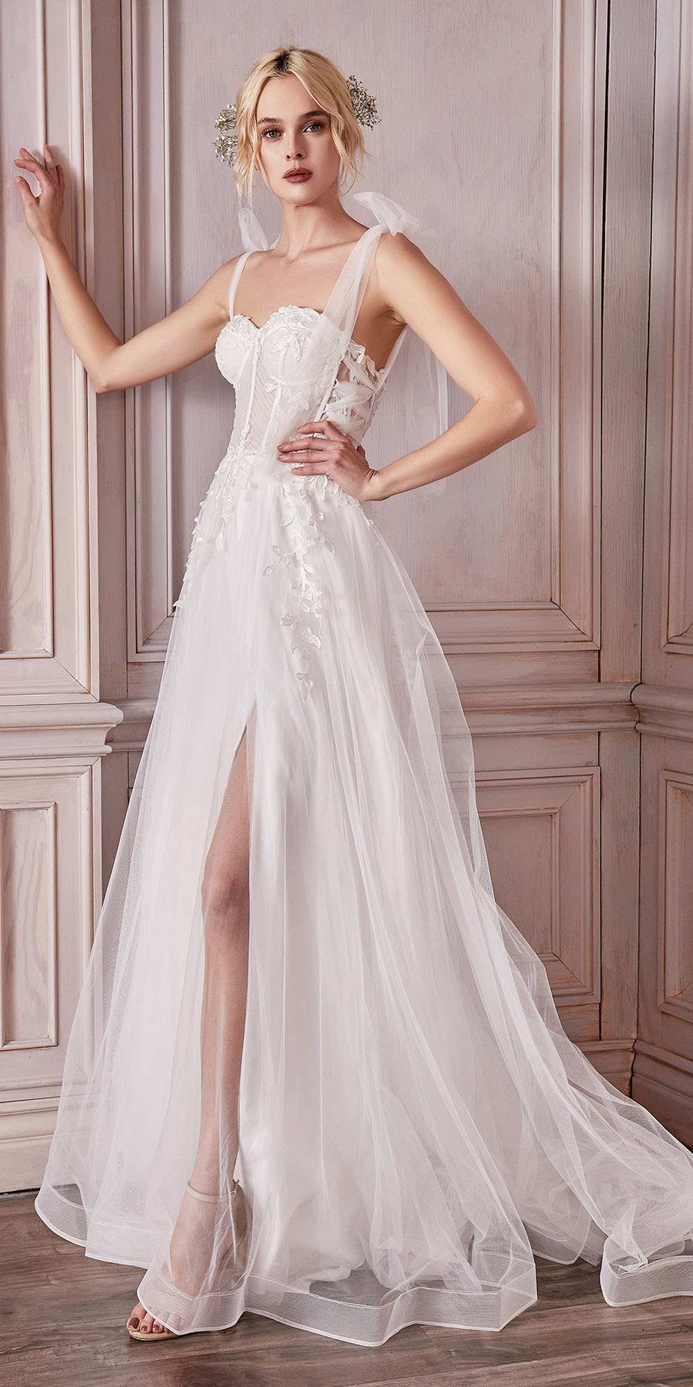 Off-white A-line wedding gown with lace corset bodice, spaghetti straps, and tulle overlay
