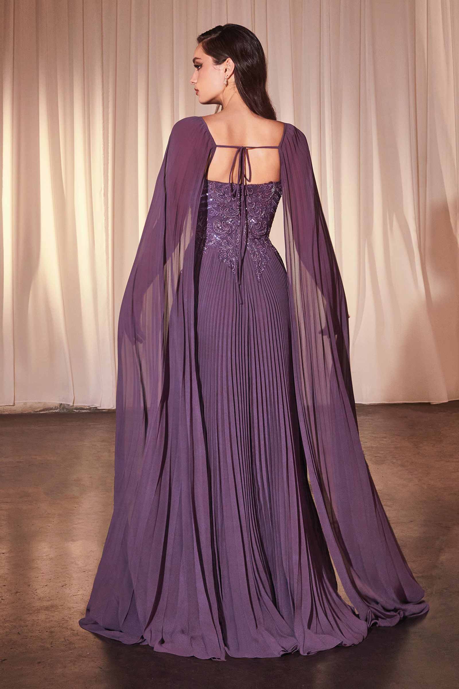Dusty lavender pleated A-line gown back view with cape sleeves and open-back detail
