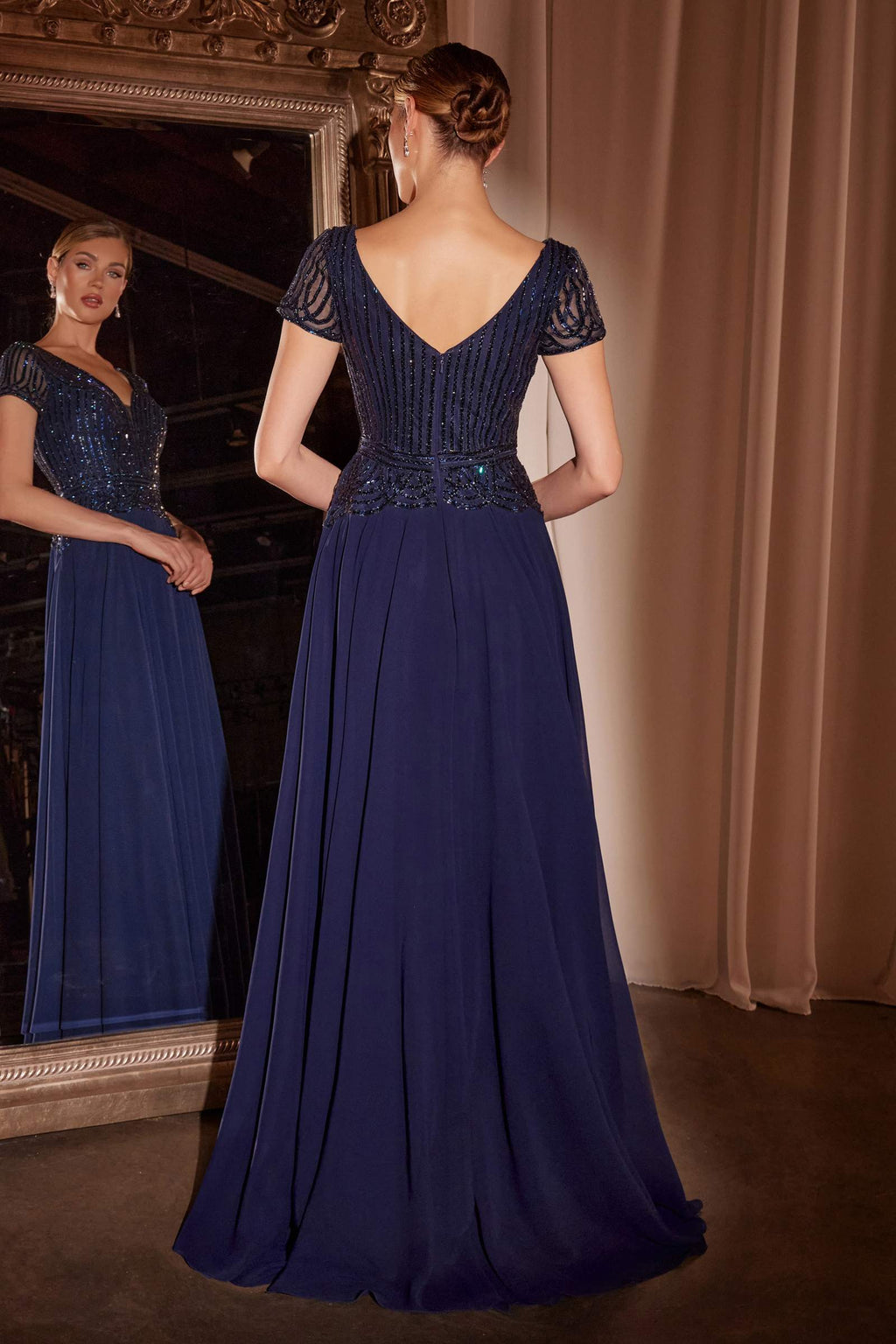 Navy A-line chiffon gown with V-back and beaded cap sleeves, pleated skirt