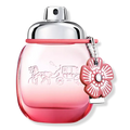 Rounded blush-pink eau de parfum bottle with red cap and floral keychain charm
