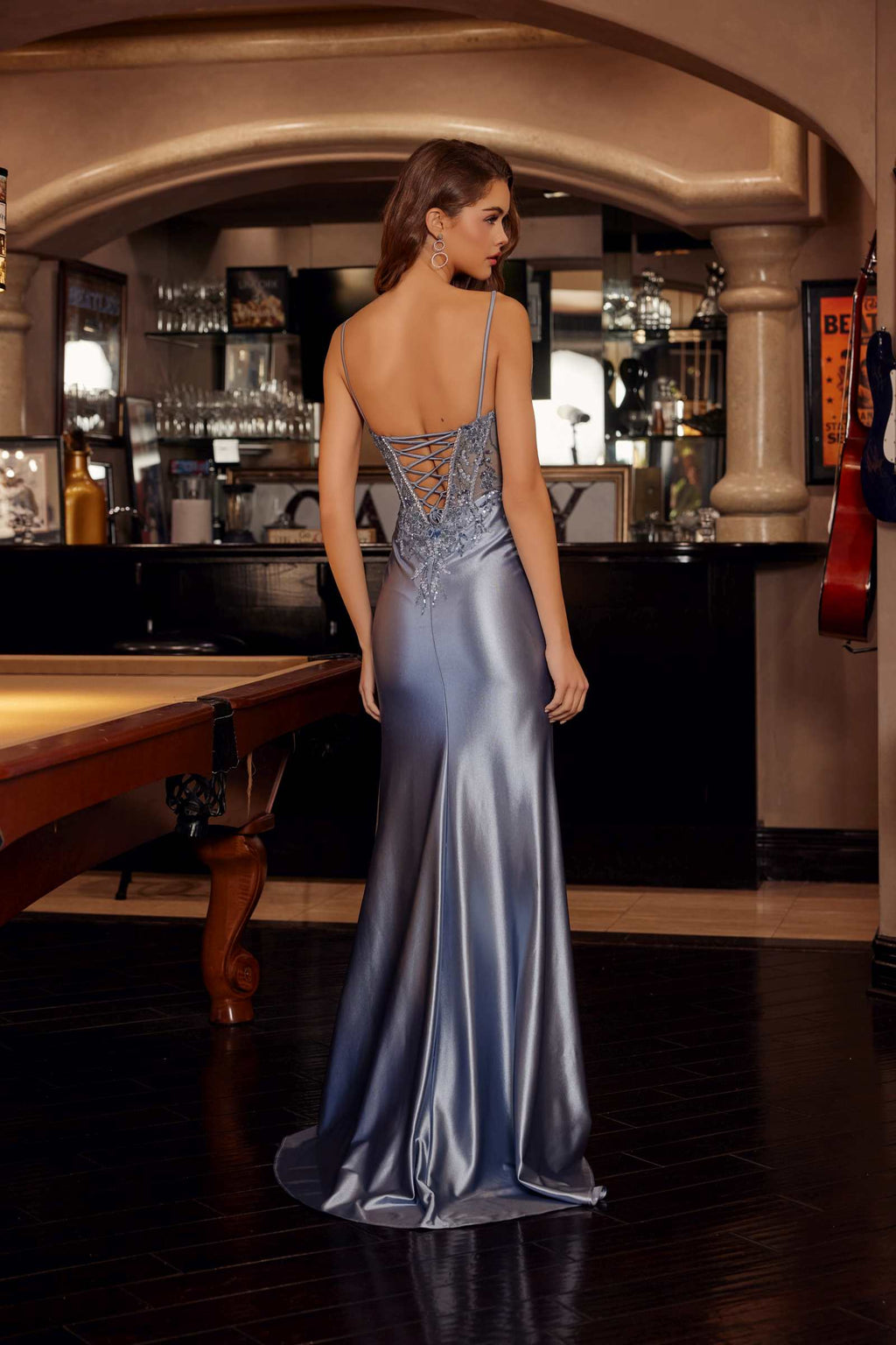 Smoky blue shiny satin prom gown back view with open-back straps and long flowing skirt